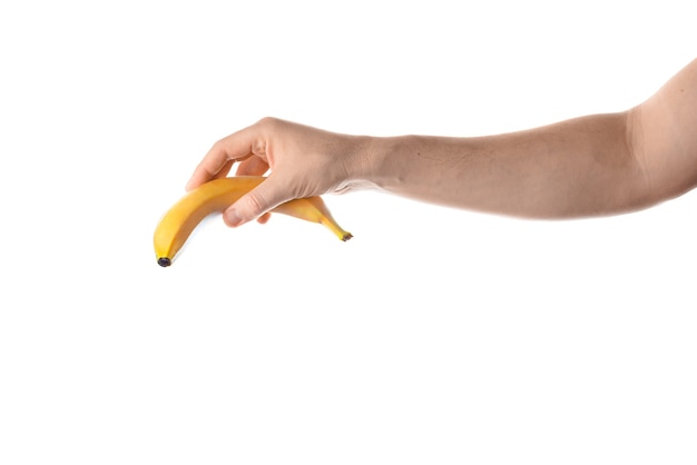 Męskiej ręki trzymającej banana. Na białym tle.