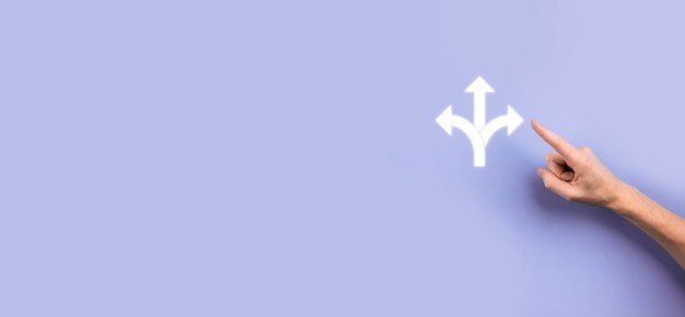 Zdjęcie męskiej ręki trzymającej ikonę z ikoną trzech kierunków na ciemnym tle. wątpliwości, mając do wyboru trzy różne opcje wskazane przez strzałki skierowane w przeciwnym kierunku koncepcji. sposoby
