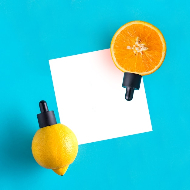 Metafora, butelka z serum, olejek cytrusowy, pomarańcza, cytryna. Pojęcie witaminy C w kosmetyce i aromaterapii.