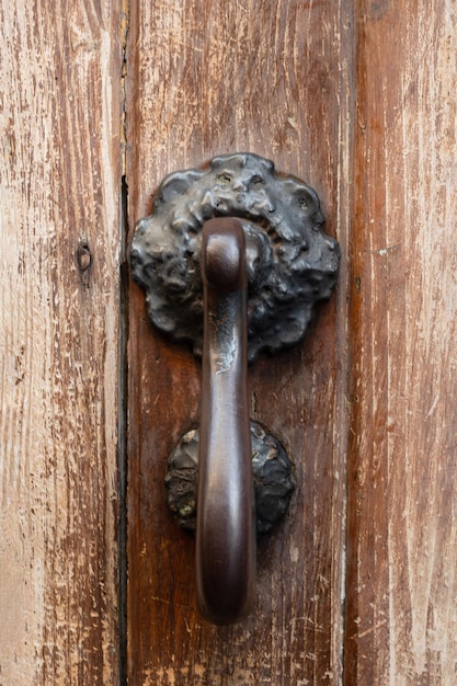 Zdjęcie metalowa starodawna stara klamka na drewnianych drzwiach i we włoszech