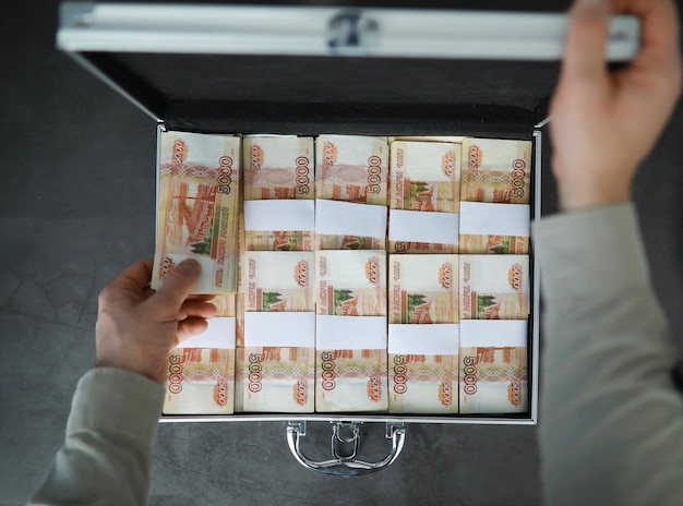 Metalowa walizka wypełniona rosyjskimi banknotami o wartości 5000 rubli Koncepcja korupcji łapówki inwestycyjnej