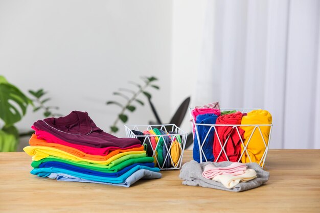Metalowe kosze z rolowanymi kolorowymi ubraniami Porządkowanie ubrań w przestrzeni wydajne przechowywanie, aby zaoszczędzić miejsce w małym mieszkaniu Codzienne i wygodne ubrania po praniu