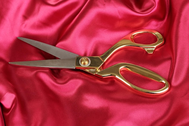 Metalowe nożyczki na czerwonej tkaninie