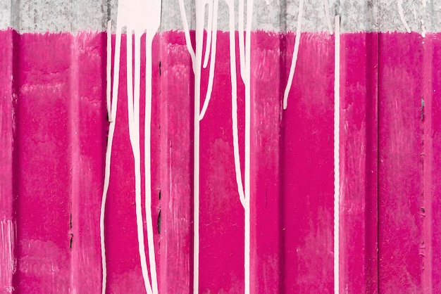 Metalowe ogrodzenie z różową i białą farbą teksturą tła