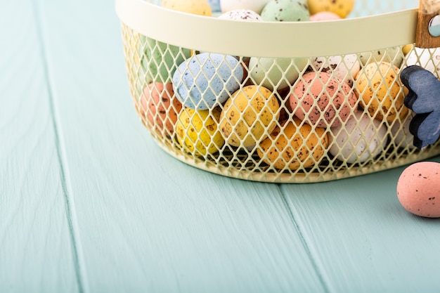Metalowy koszyczek z kolorowymi wielkanocnymi jajkami przepiórczymi. Koncepcja wakacji wiosennych z miejsca na kopię
