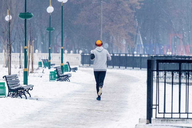 Mężczyzna biegający w parku zimowym zdrowy styl życia