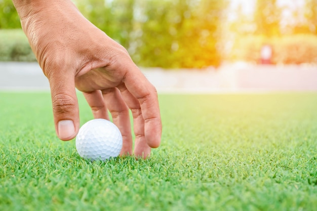 Zdjęcie mężczyzna bierze golfball na zielonej trawie