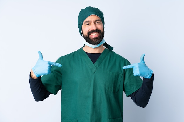 Mężczyzna chirurg w zielonym mundurze na ścianie dumny i zadowolony z siebie
