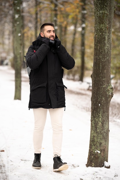 Mężczyzna chodzący w pięknym śnieżnym krajobrazie w parku Tiergarten w Berlinie Niemcy