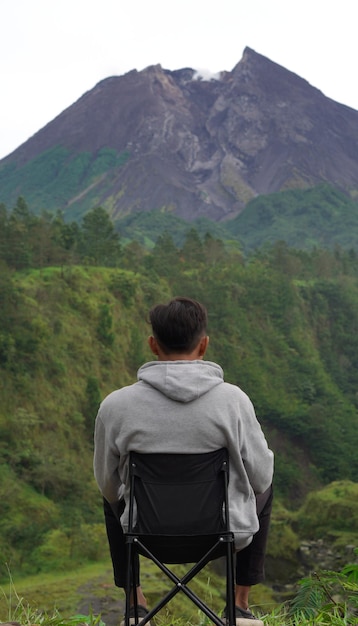 Mężczyzna cieszy się pięknym widokiem na wulkan o poranku