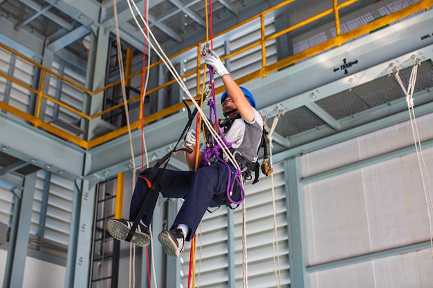 Mężczyzna ćwiczący dostęp linowy w pracy na wysokości
