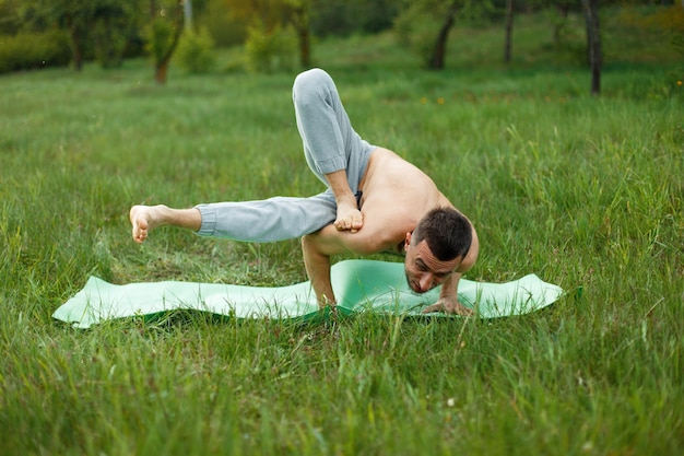 Mężczyzna ćwiczy jogę w parku