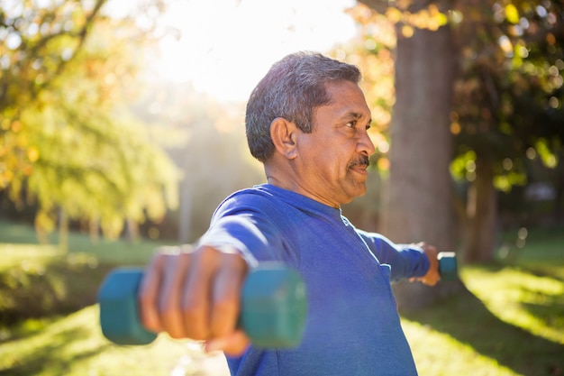 Mężczyzna ćwiczy z dumbbell na słonecznym dniu