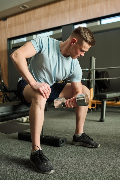 Mężczyzna ćwiczy z dumbbells w gym