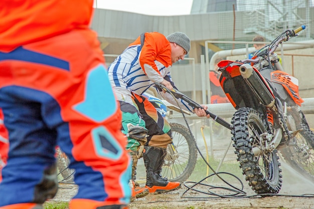 Mężczyzna czyści motocykl - motocykl wyszczególnia pojęcie. Selektywne ustawianie ostrości.