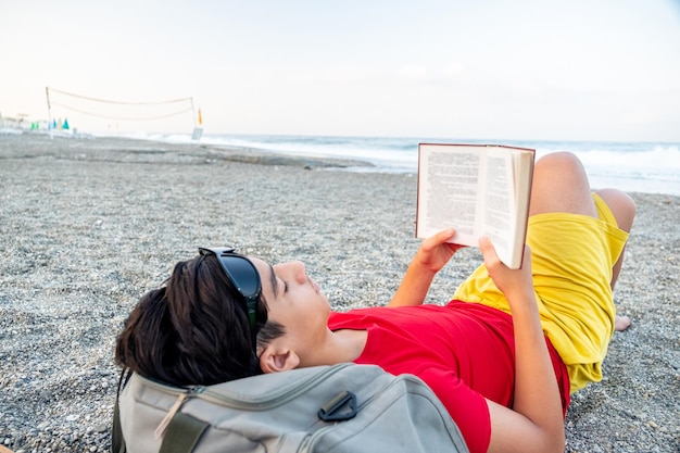 Mężczyzna czyta książkę na plaży