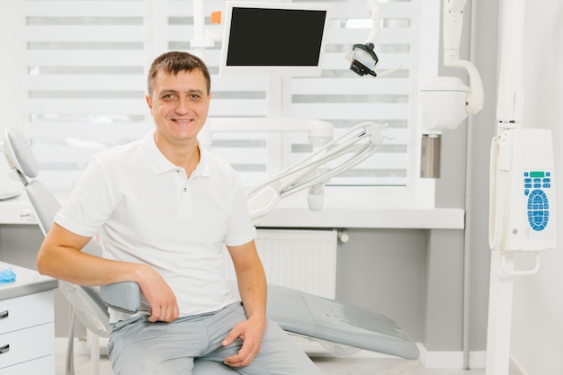 Mężczyzna dentysta przy jego miejscem pracy