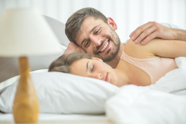 Mężczyzna dotyka kobiety w łóżku