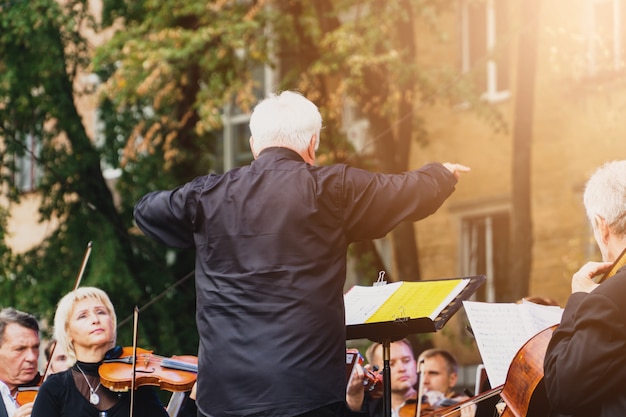 Zdjęcie mężczyzna dyrygent ze swoim zespołem na festiwalu wyprzedza w słonecznej ukraińskiej połtawie