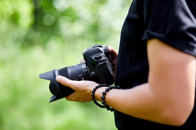 Mężczyzna fotograf z aparatem fotograficznym w ręku na zewnątrz