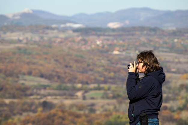 Zdjęcie mężczyzna fotografujący na tle nieba