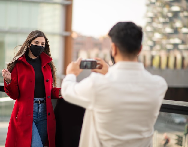 Mężczyzna fotografujący swoją dziewczynę podczas pandemii pandemii lub koronawirusa