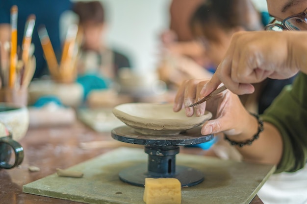 Mężczyzna Garncarz Pracujący Na Kole Garncarskim Wyrabiający Ceramiczny Garnek Z Gliny W Warsztatach Garncarskich Koncepcja Sztuki Skupienie Ręki Młody Mężczyzna Przyczepiający Glinianą Część Produktu Do Przyszłego Wyrobu Ceramicznego Warsztat Garncarski