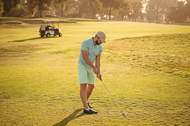 Mężczyzna golfista na profesjonalnym polu golfowym portret golfisty w czapce z kijem golfowym