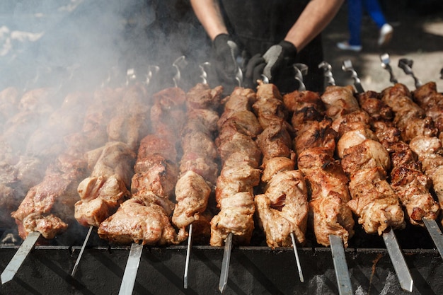 Mężczyzna gotujący z grilla z grilla spotyka się na szpikulcu na grillu węglowym