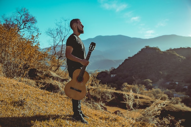 Mężczyzna gra na gitarze w górach