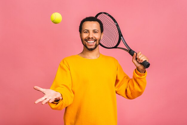 Mężczyzna Gra W Tenisa Na Białym Tle Nad Różowym. Studio Strzałów Dopasowanie Młody Gracz W Studio W Ruchu Lub Ruchu Podczas Gry Sportowej.