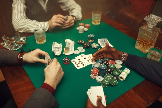 Mężczyzna graczy w pokera przy stole do gier z zielonym suknem