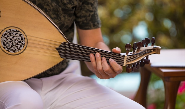 mężczyzna grający na arabskim instrumencie muzycznym