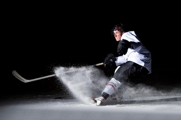 Mężczyzna grający w hokeja na lodzie w nocy