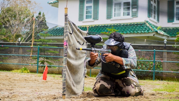 mężczyzna grający w paintball i przygotowujący się do strzału z pistoletu v.2