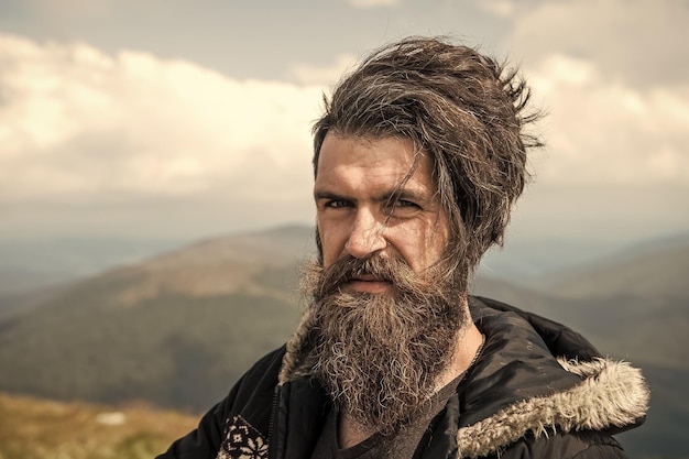 Mężczyzna hipster podróżnik z brodą i wąsami portret na górze