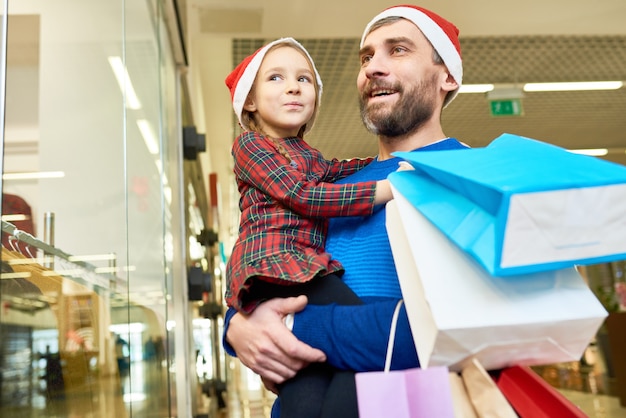 Mężczyzna i dziewczyna w Santa kapelusze zakupy razem