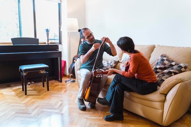 Mężczyzna i kobieta grający na gitarze w domu