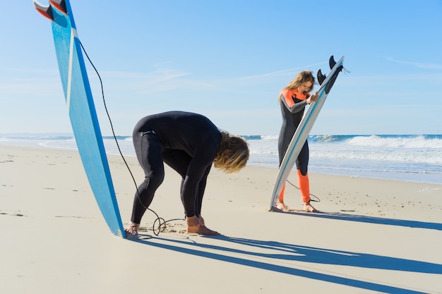 mężczyzna i kobieta idą do oceanu z desek surfingowych. mężczyzna i dziewczyna surfują