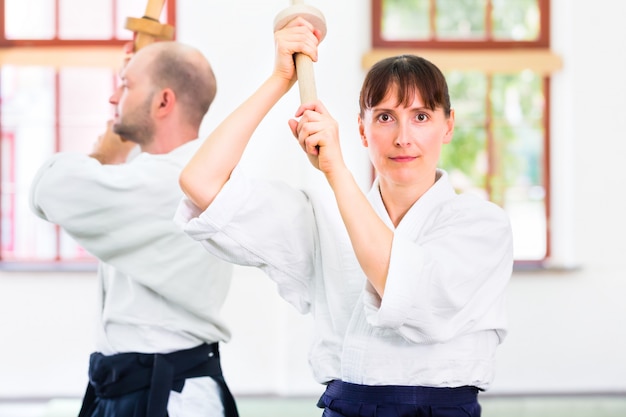 Mężczyzna i kobieta mająca walkę na miecze Aikido