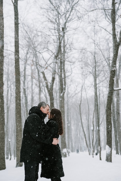 Zdjęcie mężczyzna i kobieta na pokrytym śniegiem lesie w śniegu