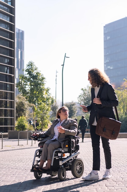 Mężczyzna i kobieta na wózku inwalidzkim rozmawiają podczas spaceru