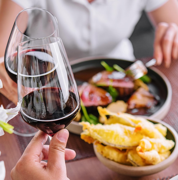 Mężczyzna i kobieta pijący czerwone wino w restauracji