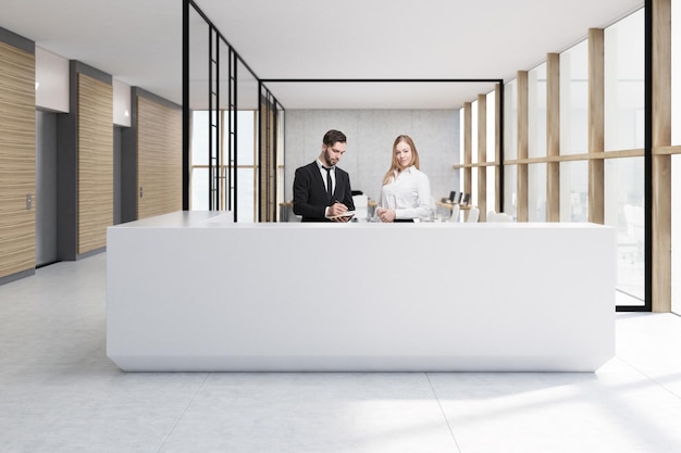 Mężczyzna i kobieta stojący przy białej recepcji stojącej w biurze ze szklanymi ścianami. W tle biurka z komputerami. renderowania 3D. Makieta.