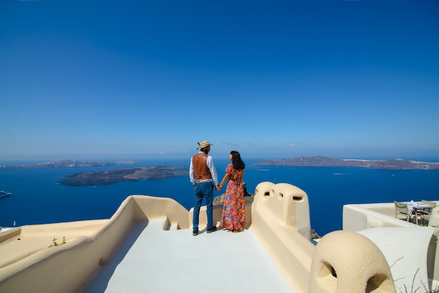 Mężczyzna i kobieta, trzymając rękę na tle na wyspie Santorini. Wieś Imerovigli. On jest etnicznym Cyganem. Ona jest Izraelką.