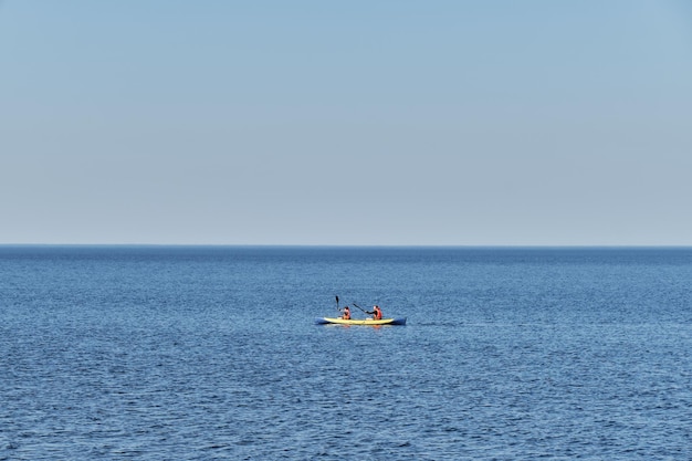 Mężczyzna i kobieta w kamizelkach ratunkowych płyną kajakiem i wiosłują przez błękitne morze Lato nad jeziorem Ładoga