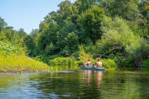 Mężczyzna i kobieta wiosłują w kajaku Rafting na szybkiej rzece Przygoda podróżowanie styl życia Koncepcja wanderlust Aktywny weekend wakacje dzika przyroda plener