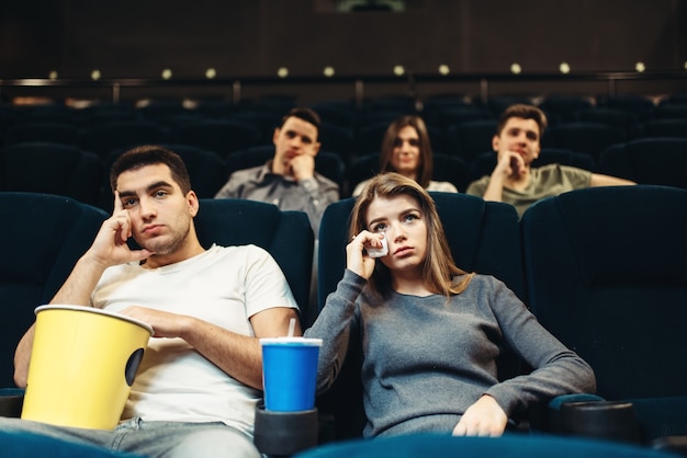 Mężczyzna i kobieta z popcornem w kinie. Nudna koncepcja filmowa, para oglądająca film