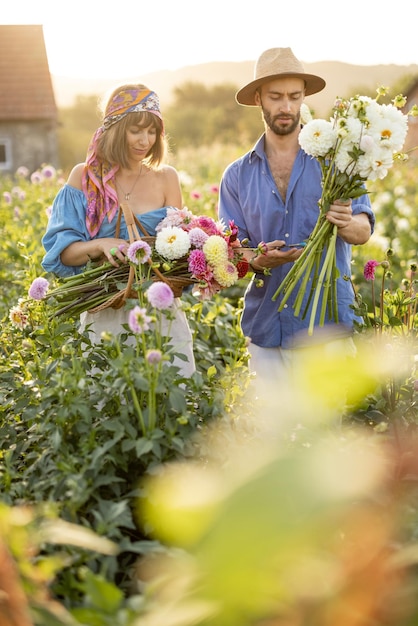 Mężczyzna i kobieta zbierają kwiaty na farmie na zewnątrz