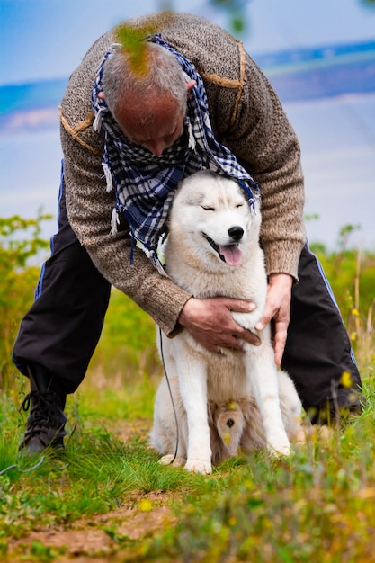 Mężczyzna I Pies Husky Chodzić W Parku.